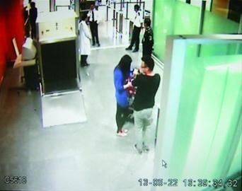 机场摄像头记录下张某抱着宠物从检验检疫办公室走出，被民警截停在到达控制区。视频截图