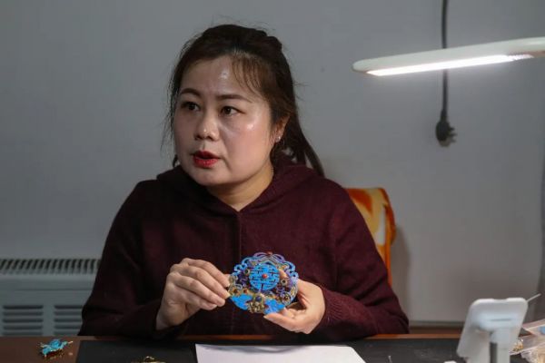 ▲肖玉妹展示此前制作的点翠制品。新京报记者 王远征 摄