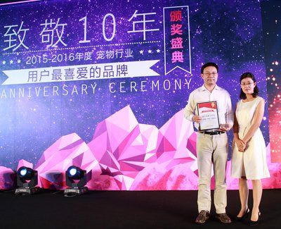 玛氏宠物护理业务总经理苏强（左）从狗民网CEO贾彤（右）手中接过“宠物食品领域最具影响力企业”奖项