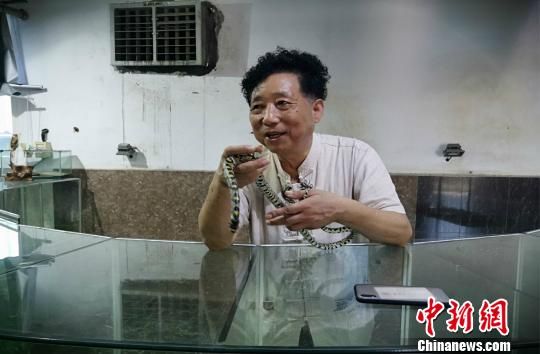 杨洪昌向游客展示活蛇 施紫楠 摄