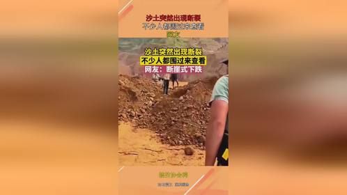 沙土突然出现断裂，不少人都围过来查看，网友：断崖式下跌！