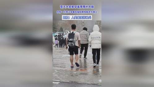 大家都穿着厚衣服，但有一位男子穿着短袖短裤拖鞋走在路上