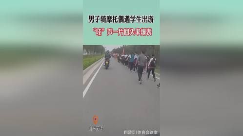 男子骑摩托车遇学生出游，学生们纷纷投来羡慕的目光