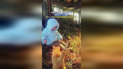 小女孩跟妈妈本来在河边晒太阳，忽然来了一只小猫咪