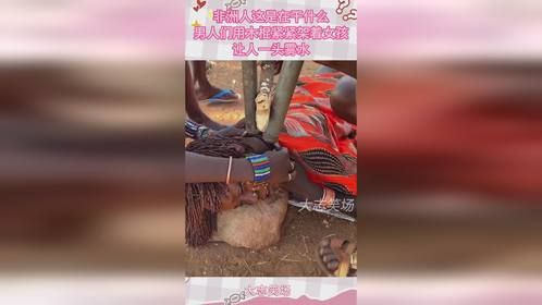 非洲人这是在干什么，男人们用木棍紧紧架着女孩，让人一头雾水