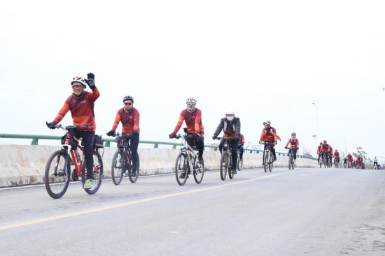 图为骑行爱好者们沿着乡村公路骑行
