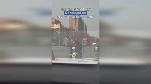 车主路上遇到可爱小朋友，跟着车里的音乐舞动。