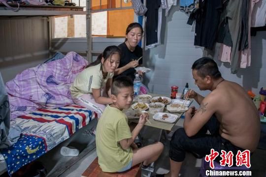 刘华芳和丈夫接孩子来工地过暑假 陈娟英 摄
