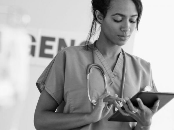 Technician holding iPad, black and white.