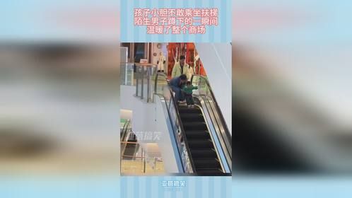 孩子小胆不敢乘坐扶梯，陌生男子蹲下的一瞬间，温暖了整个商场
