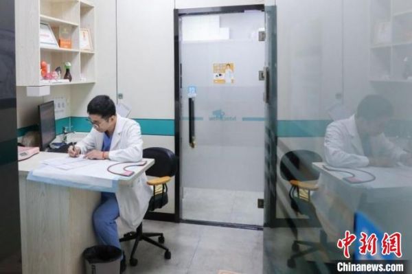 靳存宝下班前仔细复盘当日接诊病例 陆一平 摄