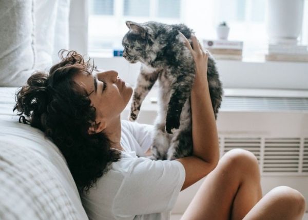 Una mujer abraza a su gato