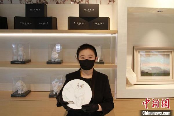图为倪雪菲展示宠物瓷盘画纪念品。　张桐若 摄