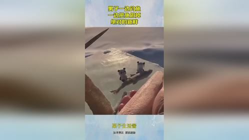 男子一边钓鱼，一边把鱼做掉，绝对的新鲜