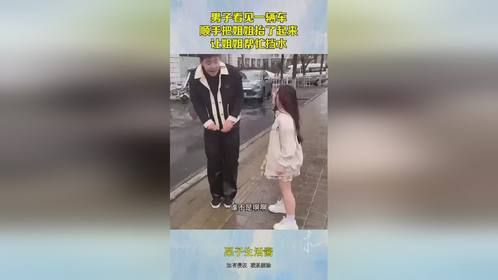 男子看见一辆车，顺手把姐姐抬了起来，让姐姐帮忙挡水