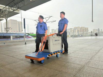 　　押运人员将宠物推上站台。 曹菲摄