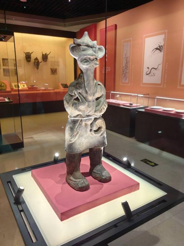 灰陶操蛇镇墓俑（东汉）。