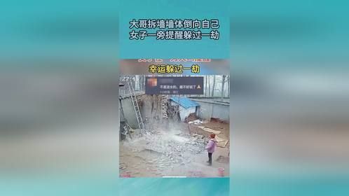 大哥拆墙墙体倒向自己，女子一旁提醒躲过一劫