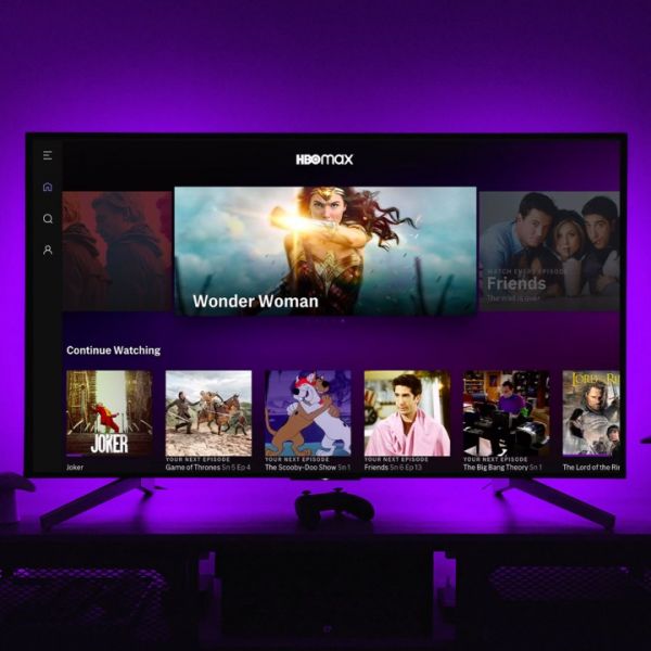 The HBO Max app on a TV screen while purple lights illuminate the wall behind.