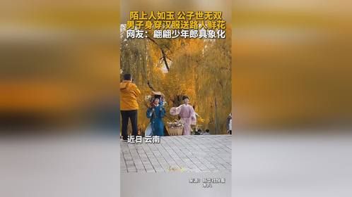 男子身穿汉服送路人鲜花。网友：翩翩少年郎具象化！