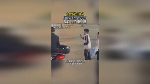 小朋友站在路边提醒未戴头盔的车主