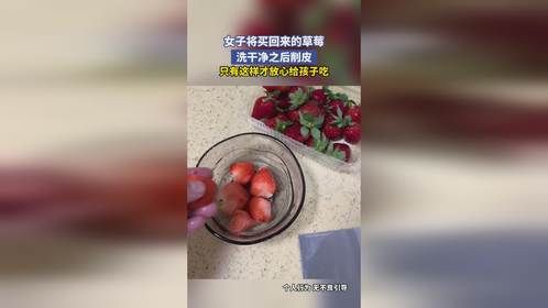 女子将买回来的草莓，洗干净之后削皮，只有这样才放心给孩子吃