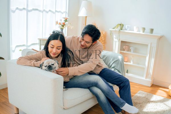 亚洲家庭在节日期间与宠物狗在家共度时光，恩爱夫妻的生活方式。照片摄影图片