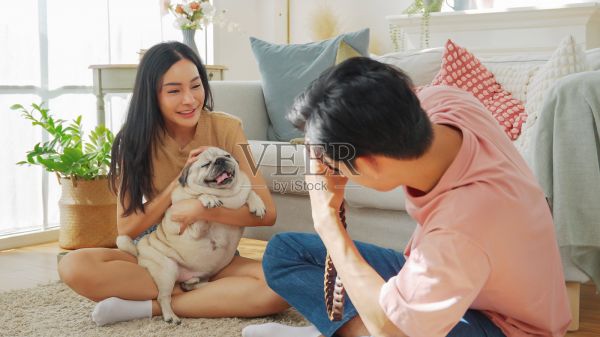 亚洲男子给坐在地上的女友和宠物狗拍照照片摄影图片