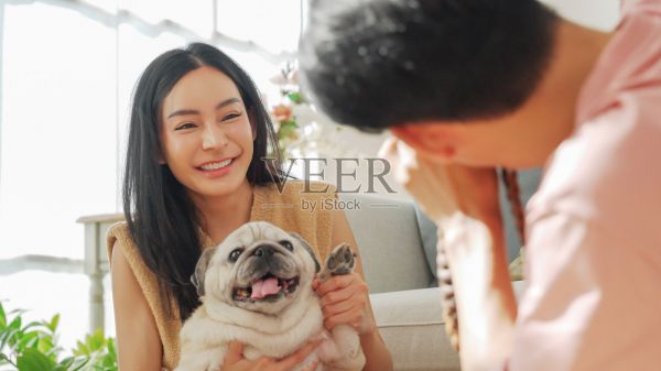 亚洲男性为正在抱宠物狗的女友拍照照片摄影图片