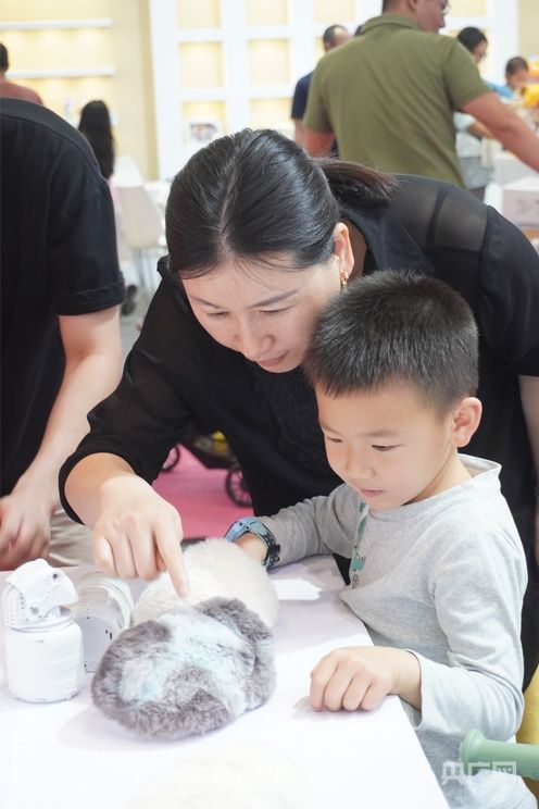 家长带孩子在展会上体验AI宠物（受访者 供图）